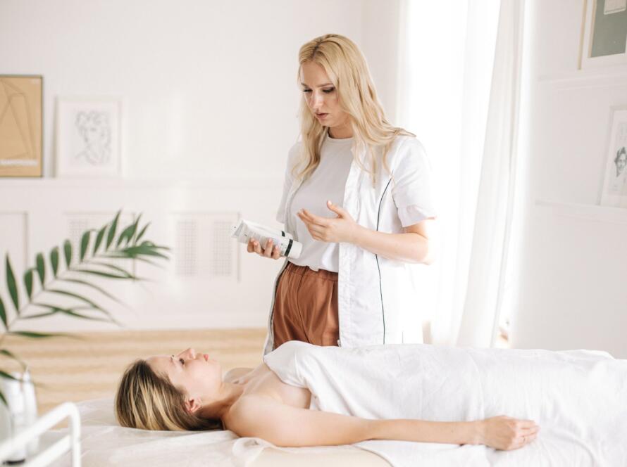 A skincare specialist conducting a facial treatment on a client in a peaceful spa setting.